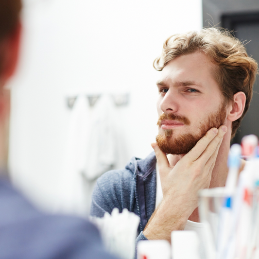 Photo of man checking beard quality in the mirror